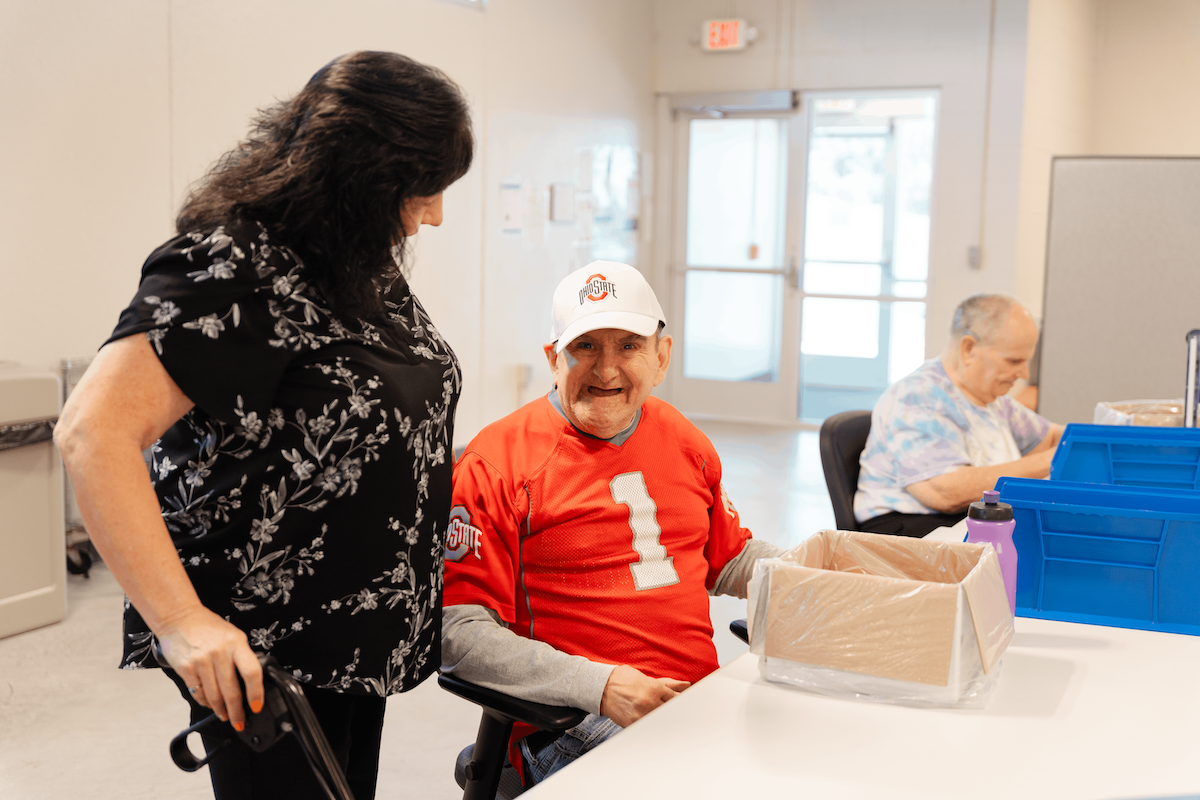 Woman speaking to a man in an orange jersey with the number 1 on it